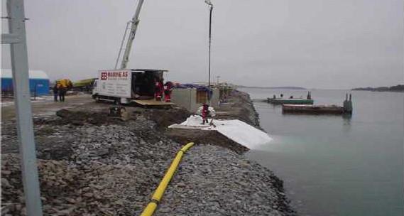 Crew working along a stone revetment at the water's edge