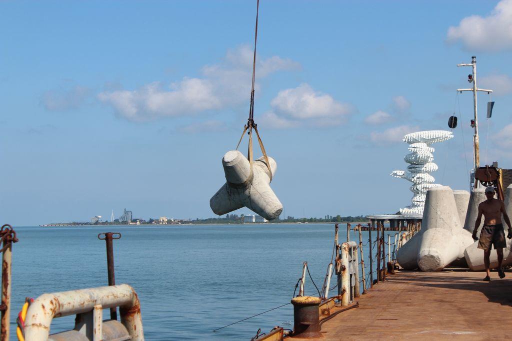 Crane lowering concrete tetrapods for bank protection